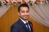 Close-up of a smiling man in a suit at a formal event in Dhaka, Bangladesh.
